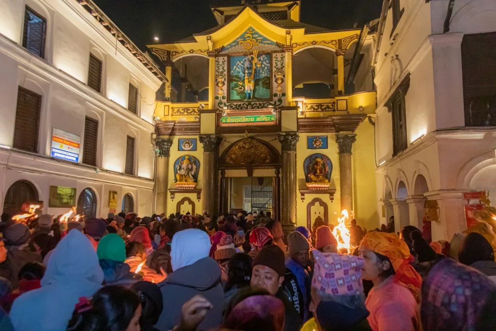 Crowd gathered for evening prayers at the decorated western gate of Pashupatinath Temple, a sacred Hindu landmark in Kathmandu, Nepal.