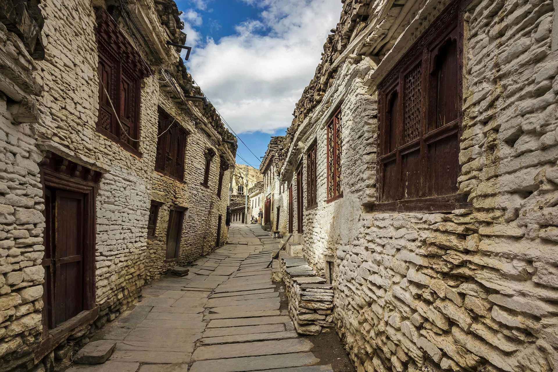 Traditional stone-paved street winding between whitewashed village houses in Marpha, Nepal