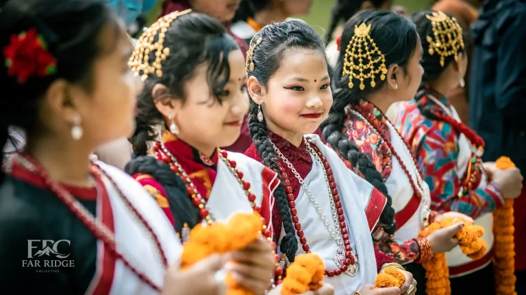 Traditional Newari girls dressed as Panchakanya in Haku Patasi attire, ready to welcome guests with marigold garlands.